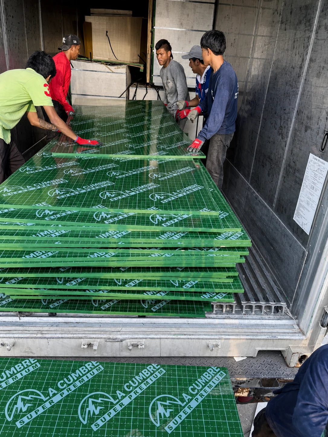 Equipo descargando tableros fenólicos para despacho de obra